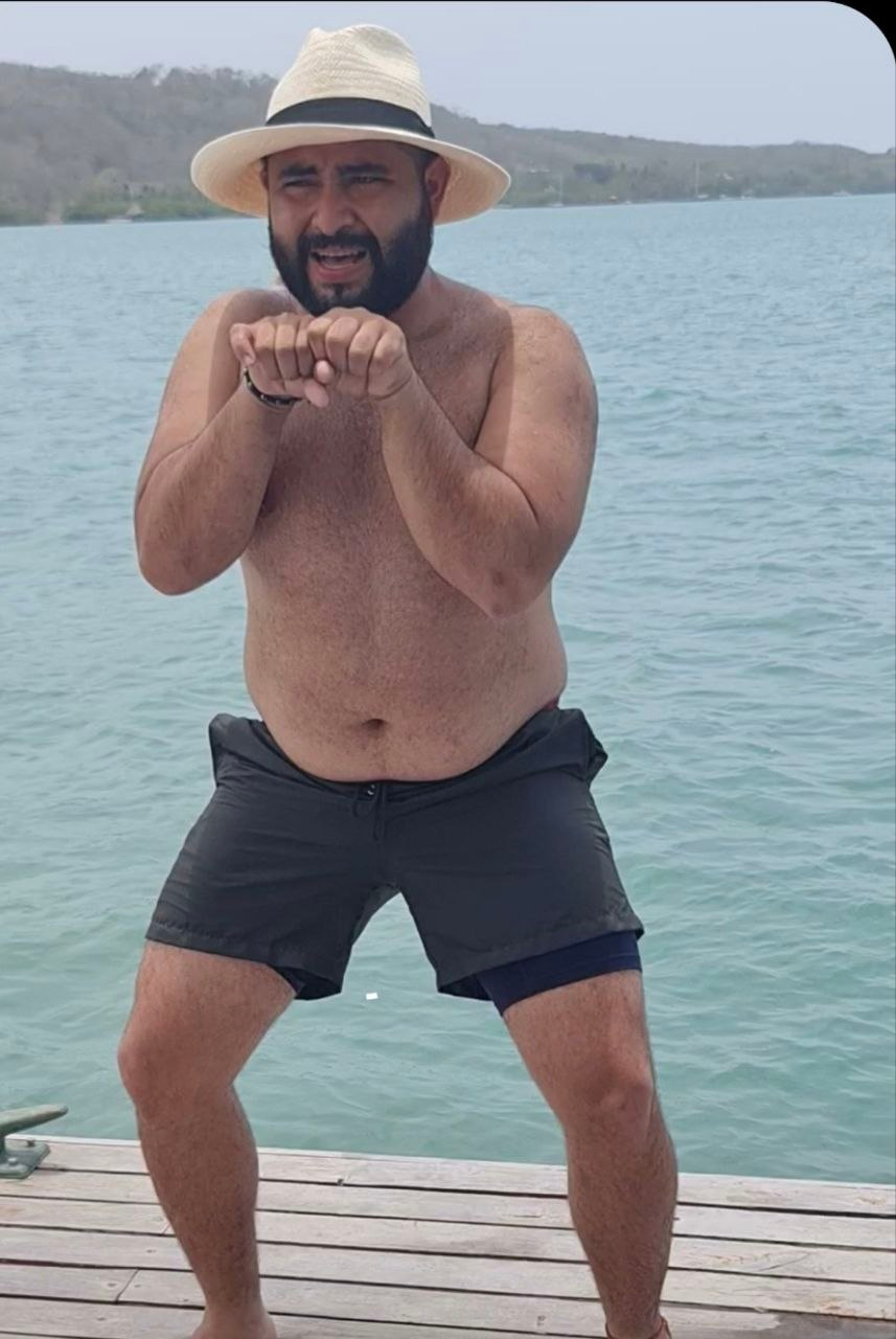Integrante en la playa haciendo una pose graciosa.